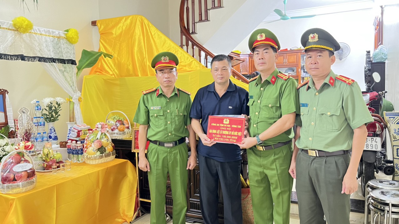 Trung tá Trần Thanh Hiển, Phó Giám đốc Công an tỉnh Bà Rịa-Vũng Tàu (thứ 2, từ phải sang) cùng Đoàn công tác Công an tỉnh trao tiền ủng hộ gia đình liệt sĩ Đỗ Đức Việt. 