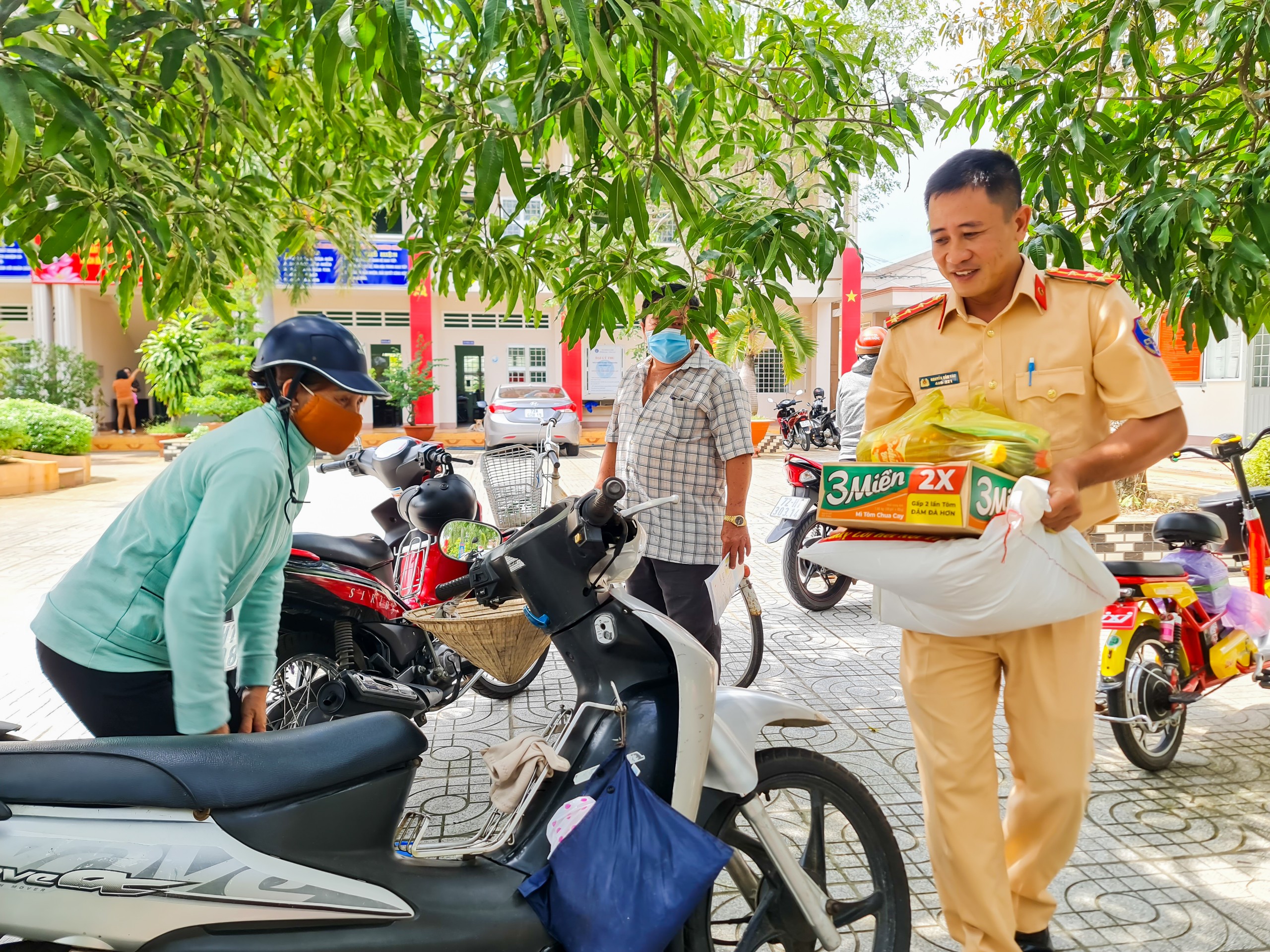 Cán bộ Phòng CSGT-Công an tỉnh đưa quà ra xe cho người dân