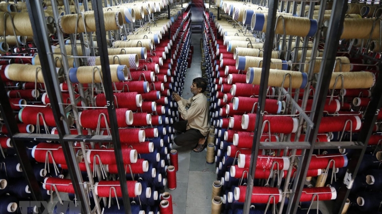 Công nhân kiểm tra các ống sợi trên máy dệt thảm tại một nhà máy ở ngoại ô Jammu, Ấn Độ.