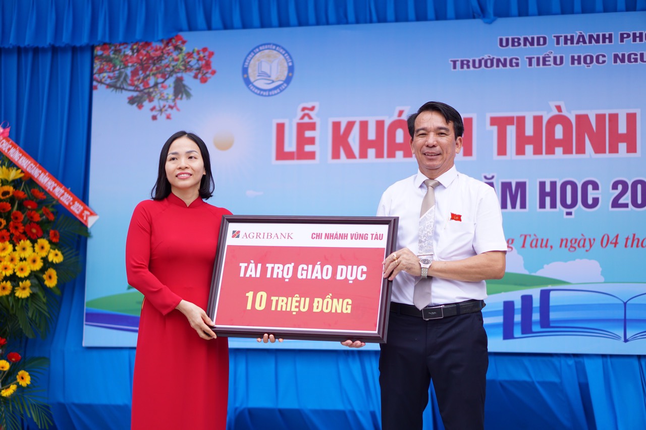 Đại diện Ngân hàng Agribank Chi nhánh Vũng Tàu trao bảng tượng trưng hỗ trợ 10 triệu đồng tài trợ học bổng cho các em HS.