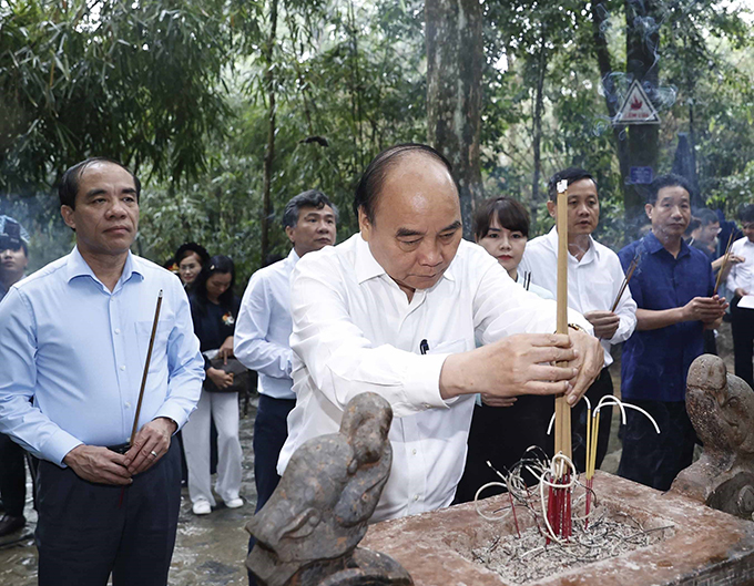 Chủ tịch nước Nguyễn Xuân Phúc cùng Đoàn công tác dâng hương tưởng nhớ Chủ tịch Hồ Chí Minh tại Lán Nà Nưa trong Khu di tích lịch sử Quốc gia đặc biệt Tân Trào. Ảnh: THỐNG NHẤT