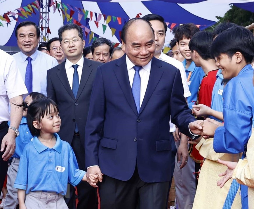 Chủ tịch nước Nguyễn Xuân Phúc chung vui Ngày hội tới trường với các em học sinh Trường TH, THCS, THPT Hy Vọng, ngôi trường liên cấp dành cho các em nhỏ mồ côi cha, mẹ do COVID-19. (Ảnh: TTXVN)