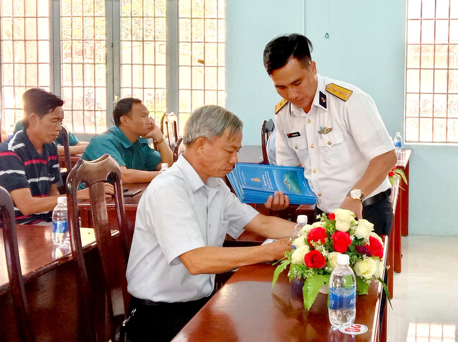 Cán bộ Lữ đoàn 171 phát tờ rơi tuyên truyền về biển đảo cho cán bộ, đảng viên xã Sông Xoài.