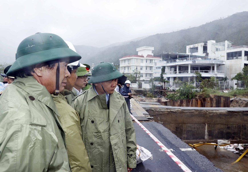 Chủ tịch nước Nguyễn Xuân Phúc và đoàn công tác kiểm tra thực địa công tác khắc phục thiệt hại các công trình hạ tầng tại điểm sạt cuối đường Lê Văn Lương, Hoàng Sa, phường Thọ Quang, quận Sơn Trà. Ảnh: Thống Nhất/TTXVN