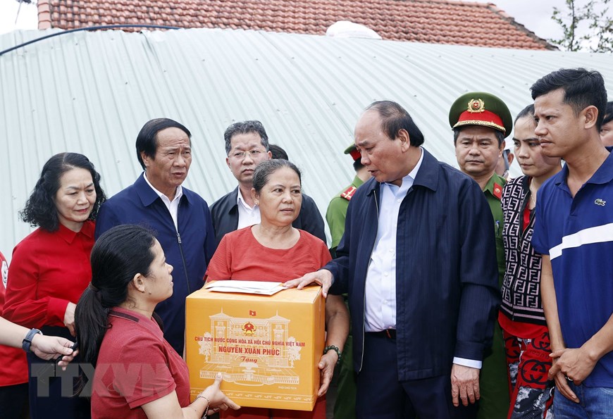 Chủ tịch nước Nguyễn Xuân Phúc và đoàn công tác tới thăm hỏi, động viên và tặng quà gia đình bà Đỗ Thị Thanh Hoa, ở thông Thạch Nam Đông, xã Hòa Nhơn, huyện Hòa Vang, TP.Đà Nẵng. Ảnh: Thống Nhất/TTXVN