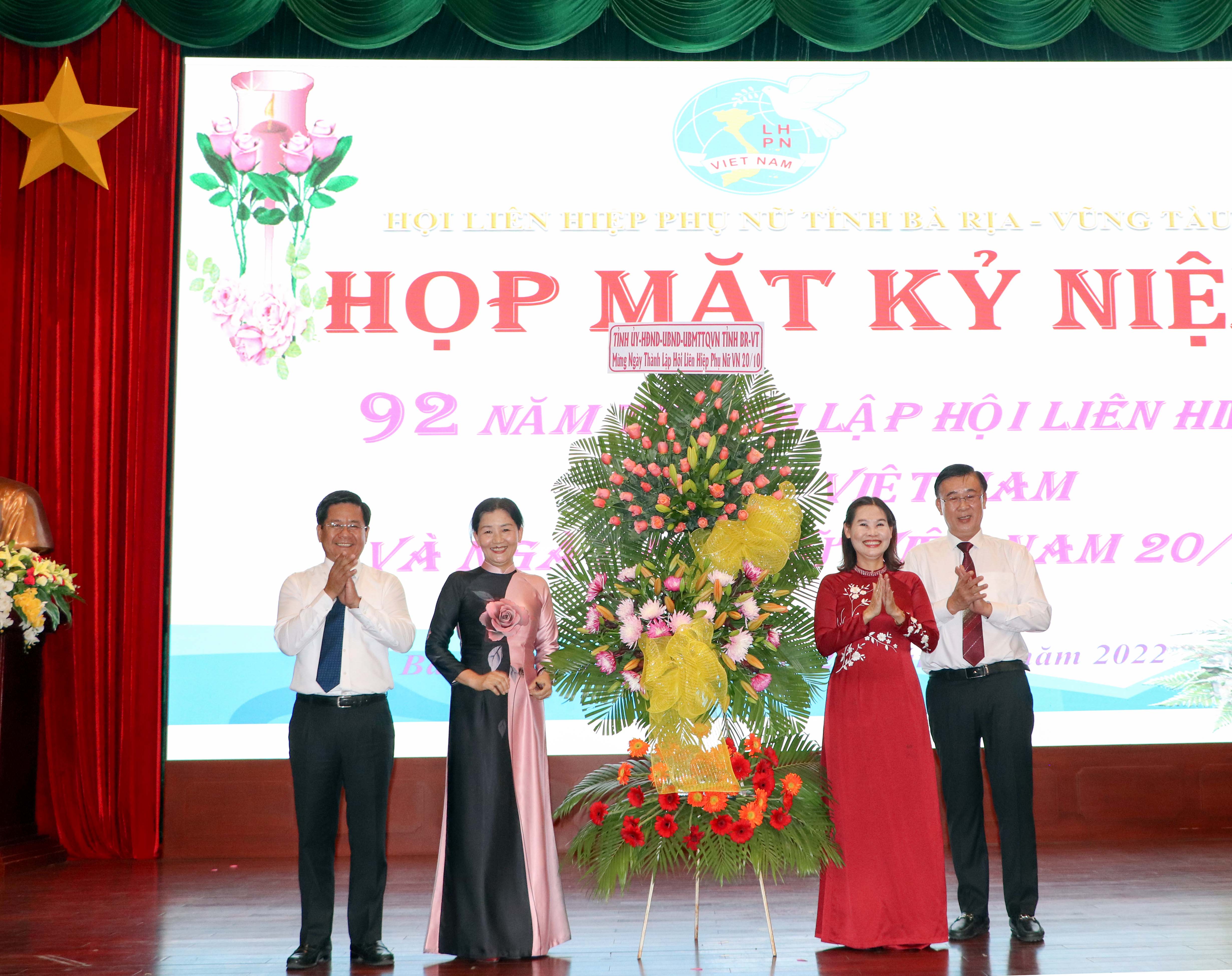 Ông Bùi Chí Thành, Chủ tịch UBMTTQ Việt Nam tỉnh (bìa trái) và ông Huỳnh Văn Danh, Trưởng Ban Dân vận Tỉnh uỷ (bìa phải) tặng hoa chúc mừng buổi họp mặt.