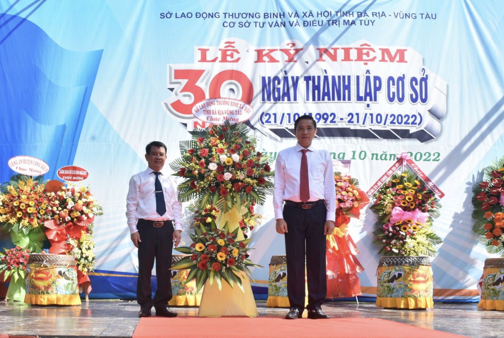 Ông Trần Quốc Khánh, Giám đốc Sở LĐTB-XH (bên phải) tặng hoa chúc mừng kỷ niệm 30 năm thành lập Cơ sở Tư vấn và Điều trị ma tuý