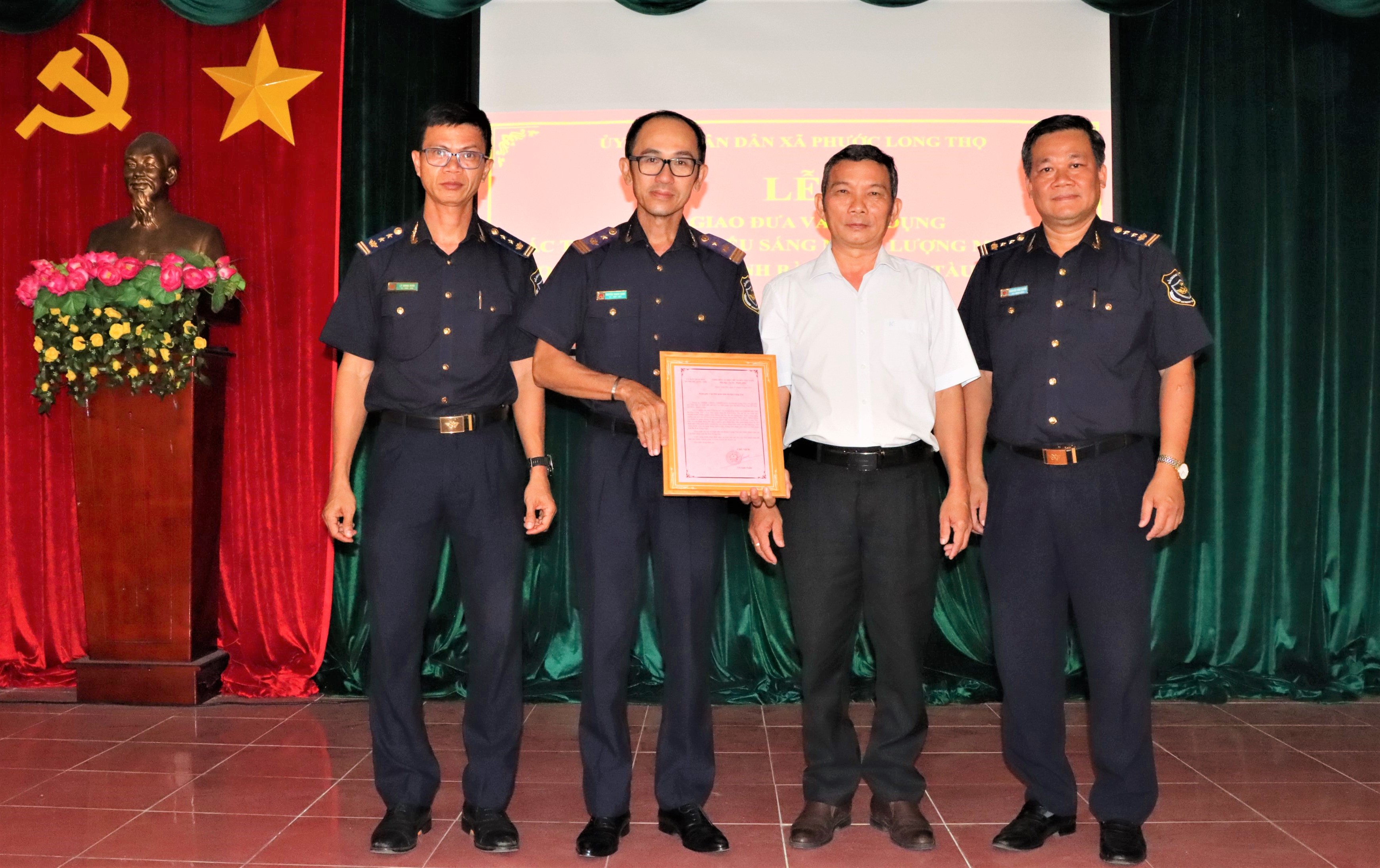Ông Trần Phước Hạnh, Bí thư đảng uỷ xã  Phước Long Thọ trao thư cám ơn cho ông Nguyễn Thanh Sang, Phó Cục Trưởng Cục Hải quan tỉnh.