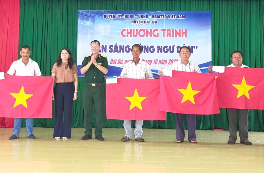 Lãnh đạo Huyện ủy, HĐND, UBND, UBMTTQVN huyện Đất Đỏ tặng quà và cờ Tổ quốc cho ngư dân.