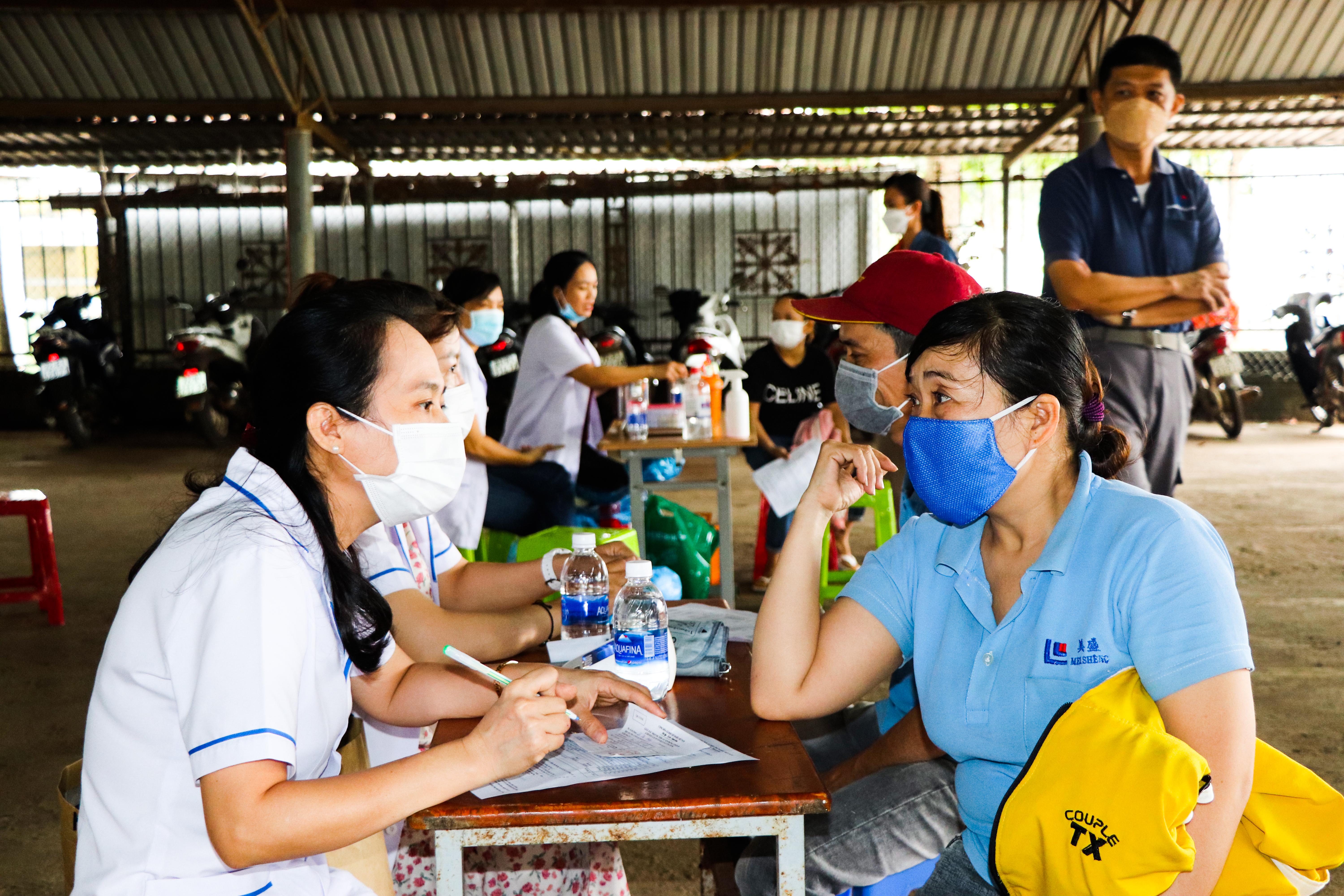 Nhân viên y tế tư vấn sức khỏe, khám sàng lọc trước khi tiêm vắc xin phòng COVID-19.