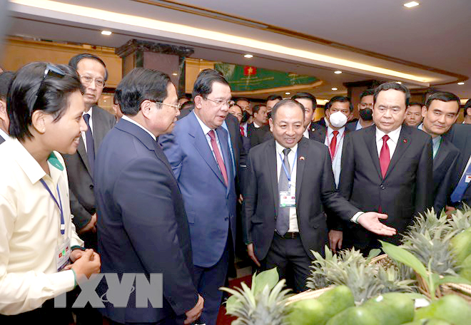 Thủ tướng Phạm Minh Chính và Thủ tướng Campuchia Samdech Techo Hun Sen tham quan gian hàng trưng bày tại Diễn đàn Xúc tiến Đầu tư và thương mại Việt Nam-Campuchia.
