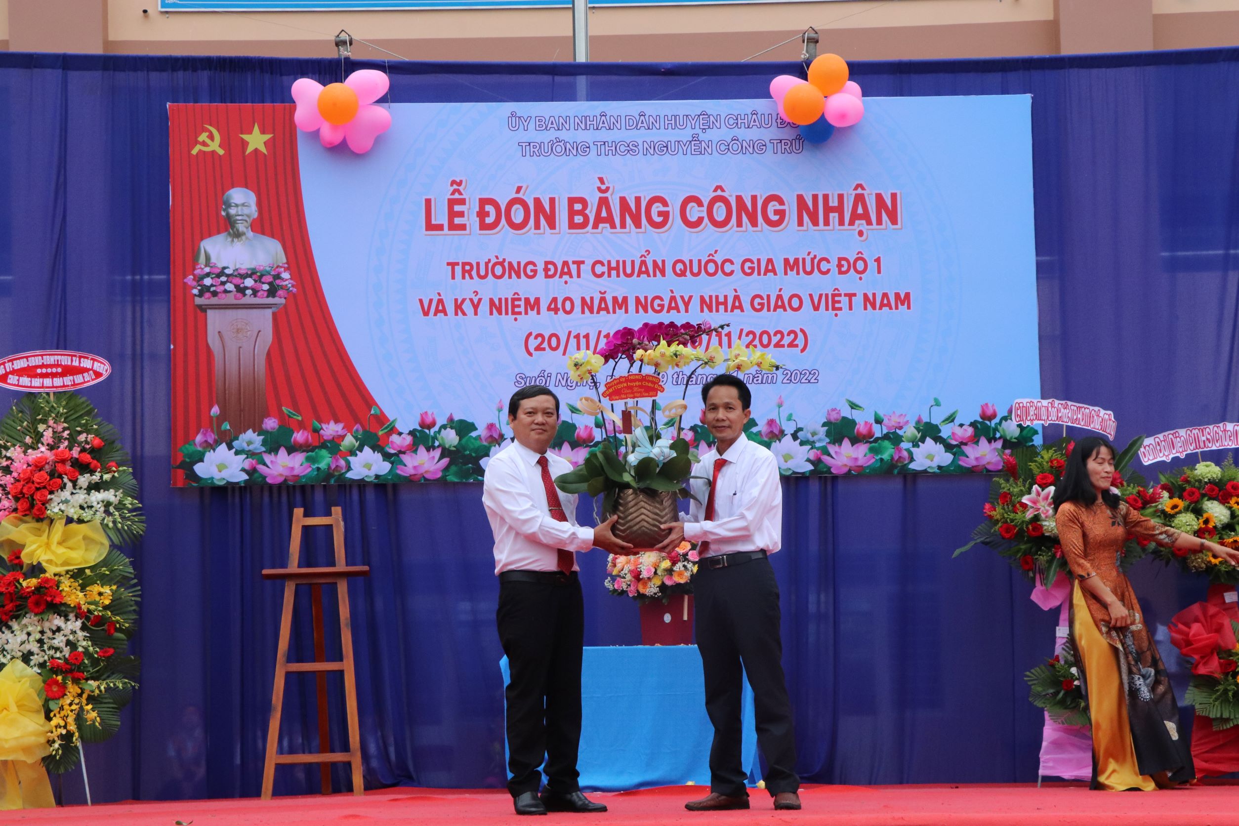 Ông Nguyễn Văn Đạt (bên phải), Hiệu trưởng Trường THCS Nguyễn Công Trứ nhận lẳng hoa chúc mừng do Phòng GD-ĐT huyện trao tặng.
