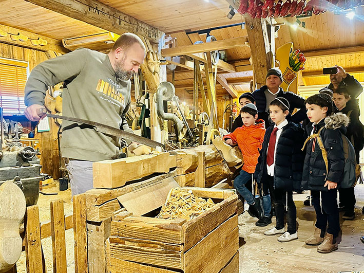 Các em nhỏ thích thú khi xem nghệ nhân trình diễn quy trình sản xuất guốc gỗ tại làng Zaanse Schans