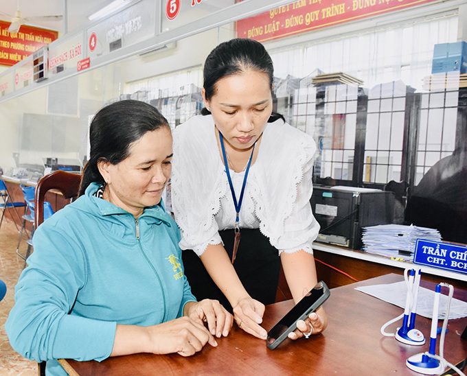 Cán bộ Bộ phận một cửa thị trấn Ngãi Giao (huyện Châu Đức) hướng dẫn người dân cài đặt và sử dụng dịch vụ công trực tuyến.