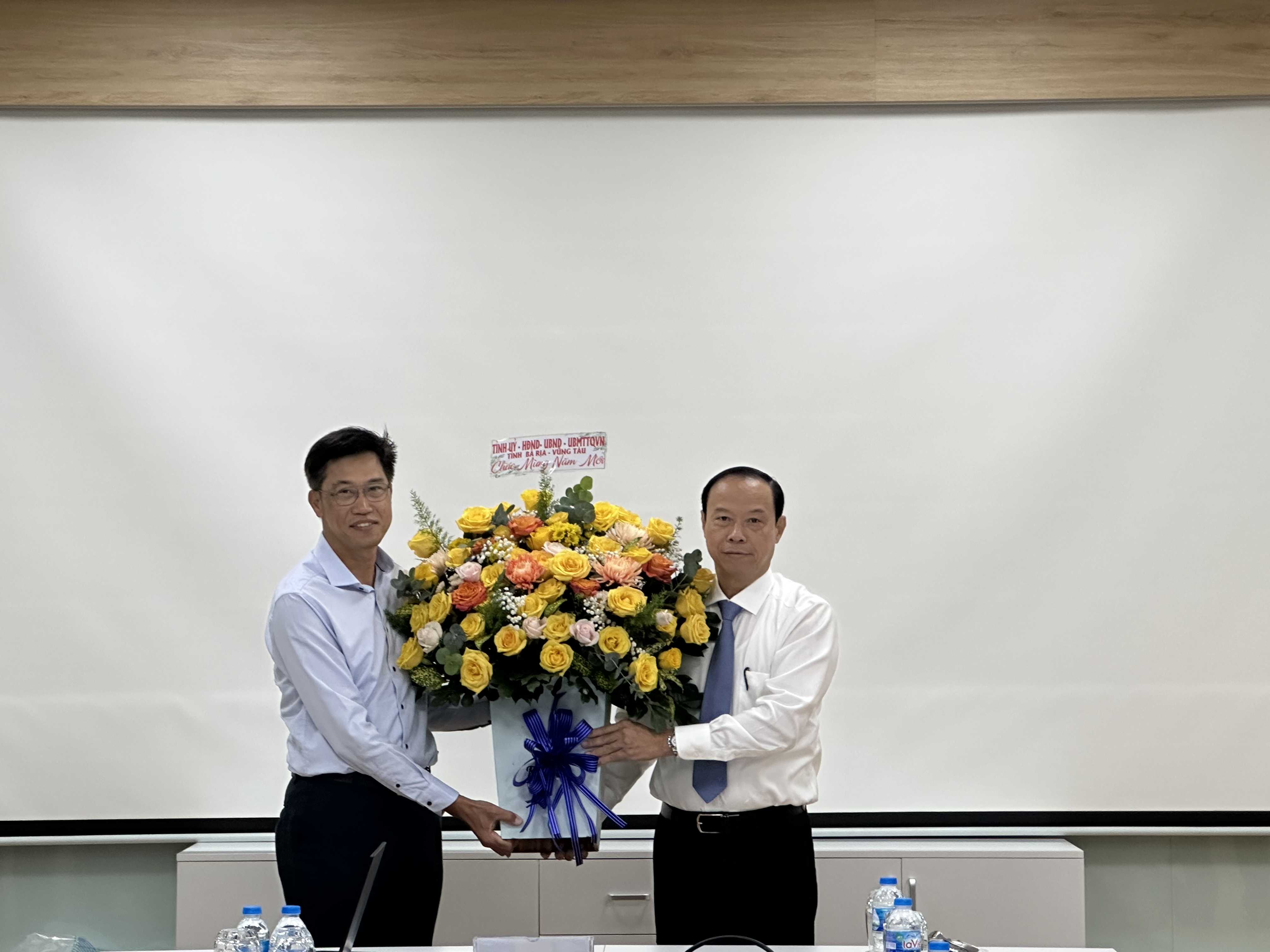 Ông Nguyễn Văn Thọ, Chủ tịch UBND tỉnh tặng hoa và quà Tết  cho đại diện Công ty TNHH Hoá dầu Long Sơn. Ảnh: TRÀ NGÂN