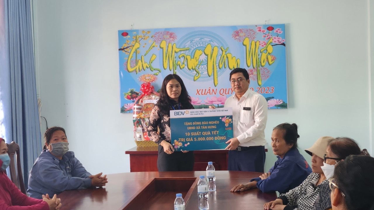 Đại diện BIDV ( bìa phải) tặng quà cho người nghèo xã Tân Hưng ( TP. Bà Rịa). 