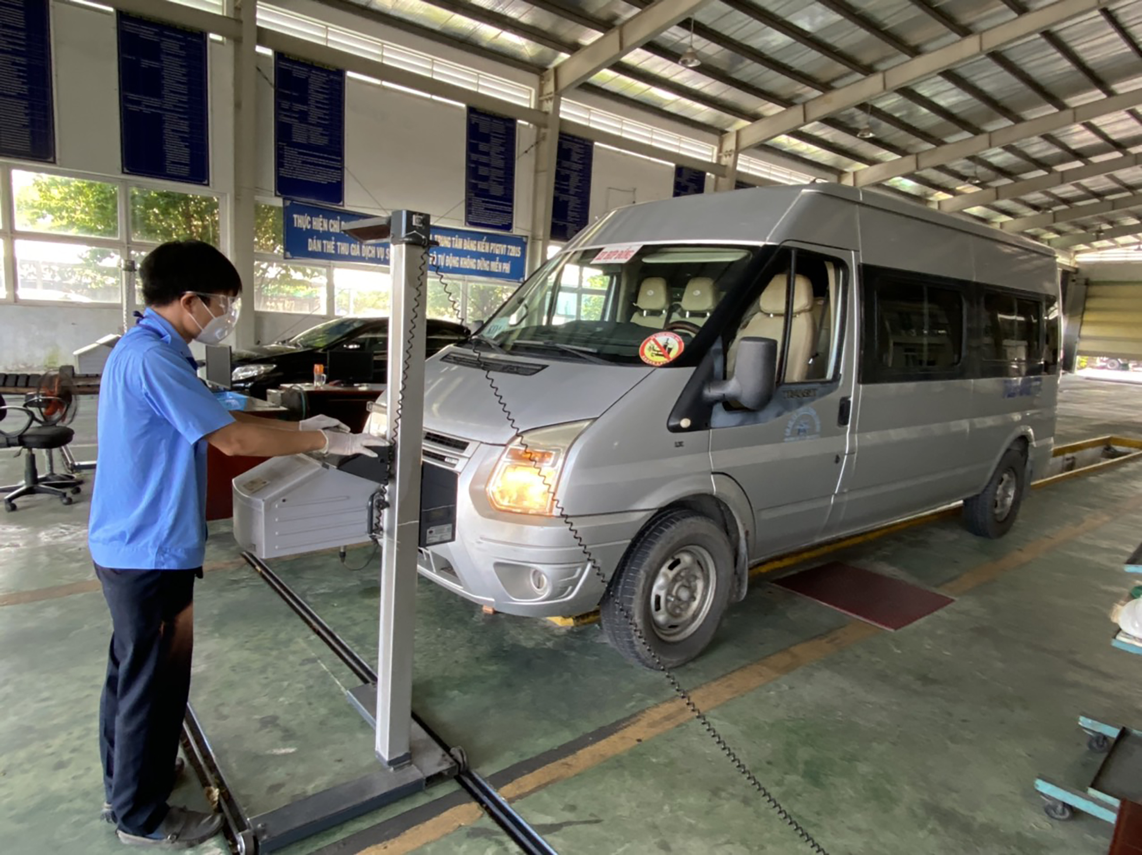 Đăng kiểm viên Trung tâm Đăng kiểm phương tiện GT-VT tỉnh thực hiện đăng kiểm phương tiện cho khách hàng. Ảnh: THÀNH HUY