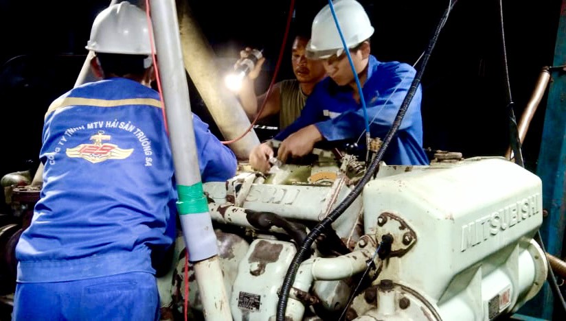 Nhân viên Trung tâm Dịch vụ hậu cần - kỹ thuật  đảo Trường Sa khắc phục sự cố hư hỏng hệ thống nhiên liệu máy chính cho tàu cá BTh 95929 TS.