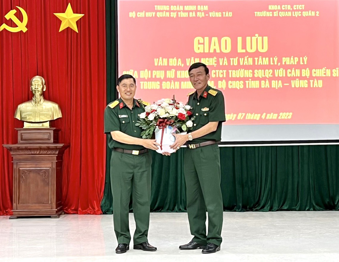 Đại tá, TS Nguyễn Văn Thắng, Chủ nhiệm Khoa Công tác Đảng, công tác chính trị Trường Sĩ quan lục quân 2 tặng hoa cho cán bộ, chiến sĩ Trung đoàn Minh Đạm.