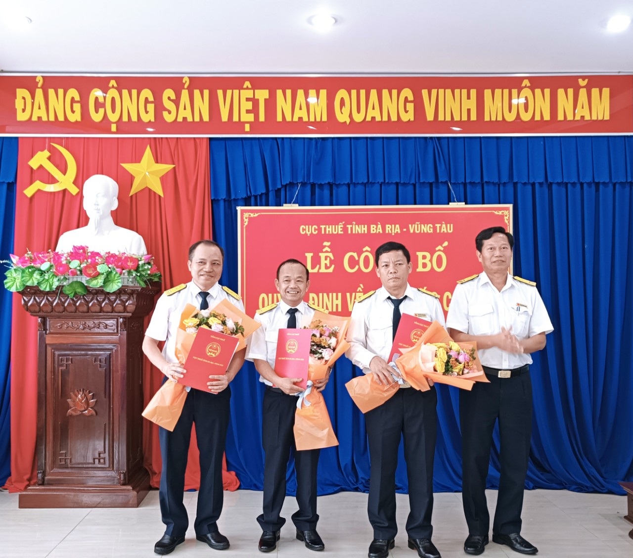 Ông Nguyễn Minh Cường, Phó Cục trưởng Cục Thuế tỉnh trao quyết định và tặng hoa chúc mừng các cán bộ được điều động, bổ nhiệm.