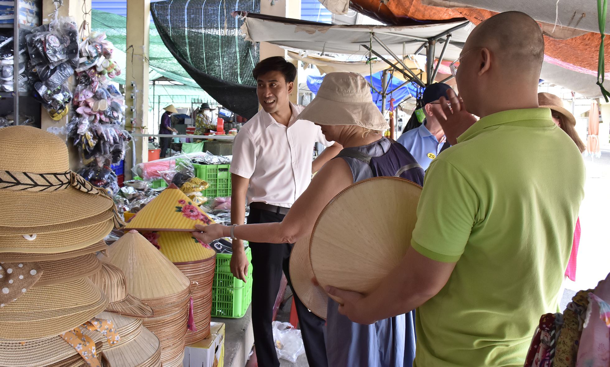 Du khách nước ngoài tham quan kios bán nón, mũ của bà Nguyễn Thị Kim Thủy tại chợ Hòa Long (TP.Bà Rịa).