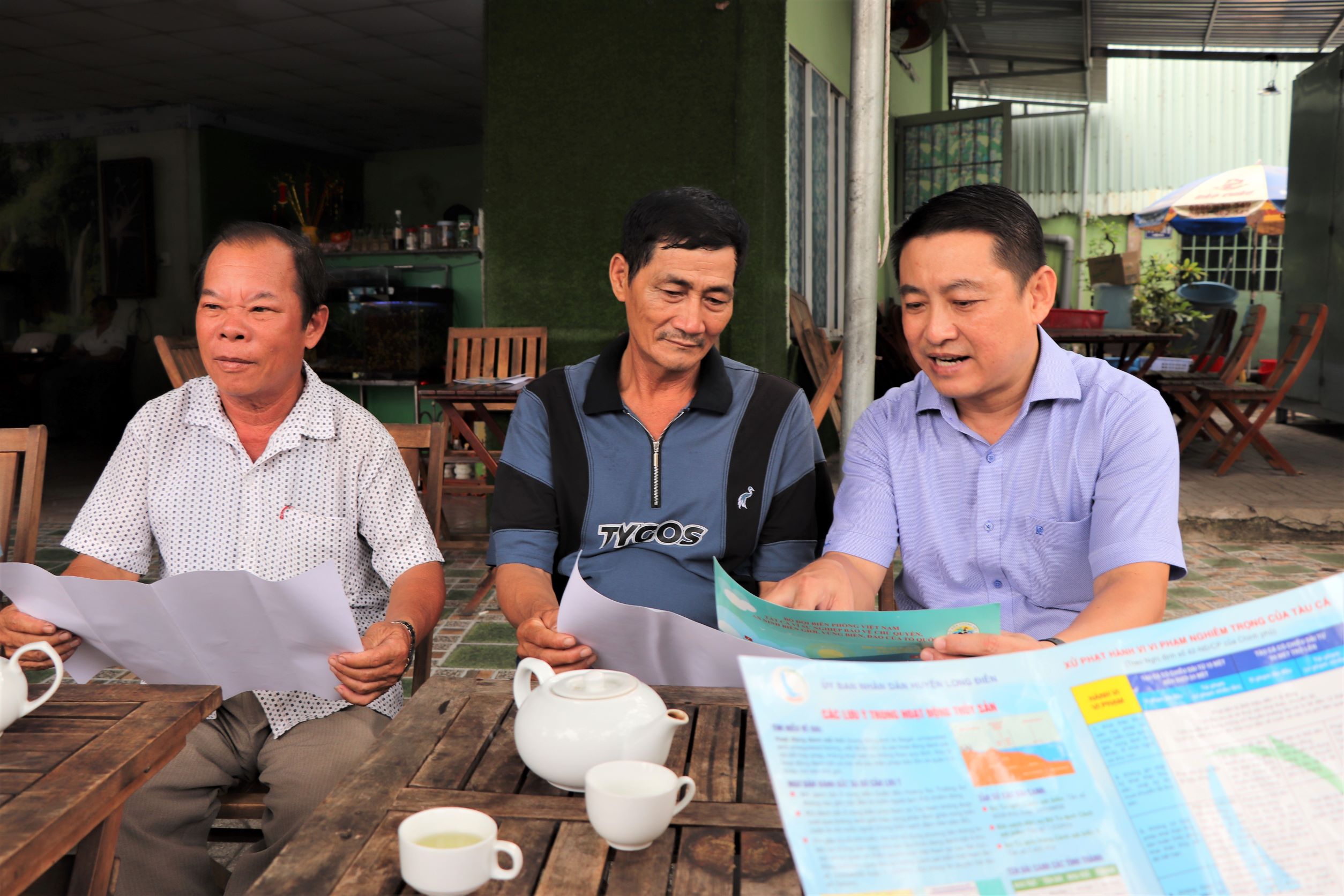 Ông Huỳnh Sơn Tuấn (bên phải), Bí thư Huyện ủy Long Điền trao đổi với ngư dân về việc chống khai thác hải sản bất hợp pháp, không theo quy định (IUU).