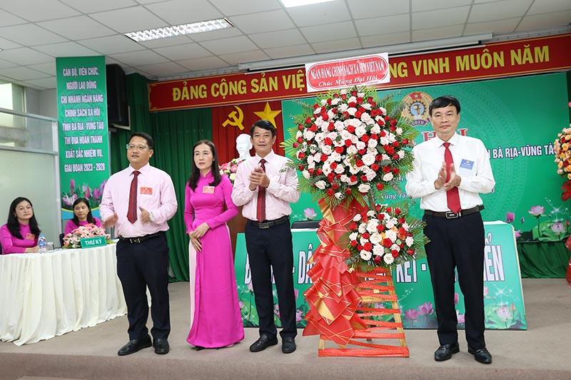  Ông Bùi Quang Vinh- Phó Bí thư Đảng ủy, Phó Tổng Giám đốc NHCSXH Việt Nam ( bìa phải) tăng hoa chúc mửng đại hội. 