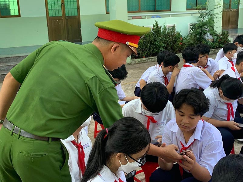 Cán bộ, chiến sĩ Đội Cảnh sát quản lý hành chính về trật tự xã hội Công an huyện Long Điền hướng dẫn học sinh trường THCS Phạm Hồng Thái (TT. Long Hải) tải ứng dụng VneID