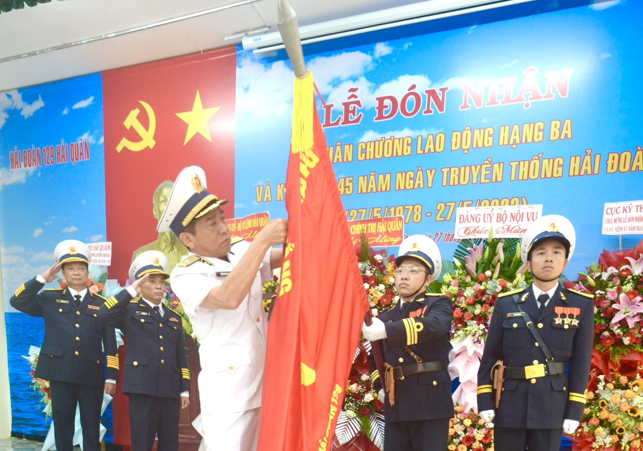 Chuẩn đô đốc Nguyễn Đình Hùng, Phó Tư lệnh Quân chủng Hải quân gắn Huân chương Lao động hạng Ba lên Quân kỳ Quyết thắng của Hải đoàn 129.
