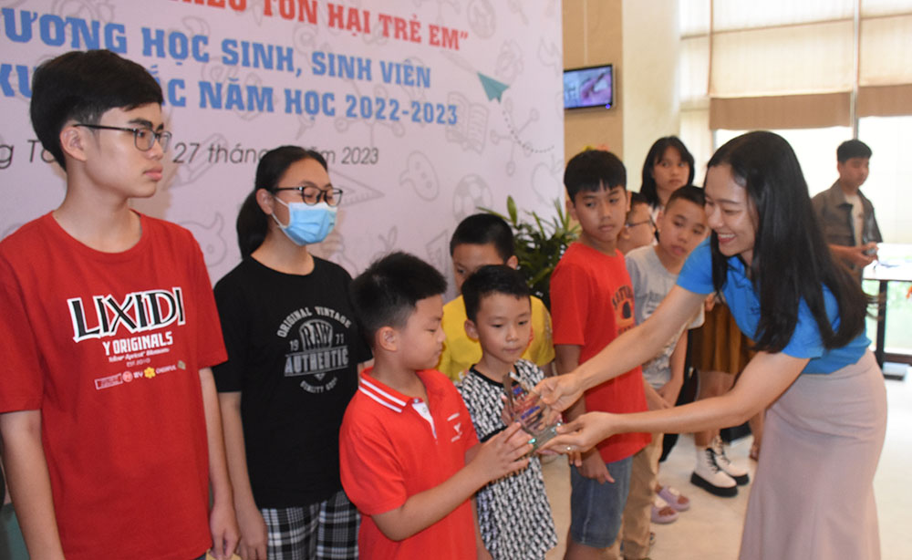 Bà Nguyễn Thị Kim Nhung, Phó Bí thư Đảng ủy, Chủ tịch Công đoàn DIC Group tặng kỷ niệm chương cho các em học sinh đạt danh hiệu học sinh giỏi cấp thành phố, cấp tỉnh và cấp quốc gia