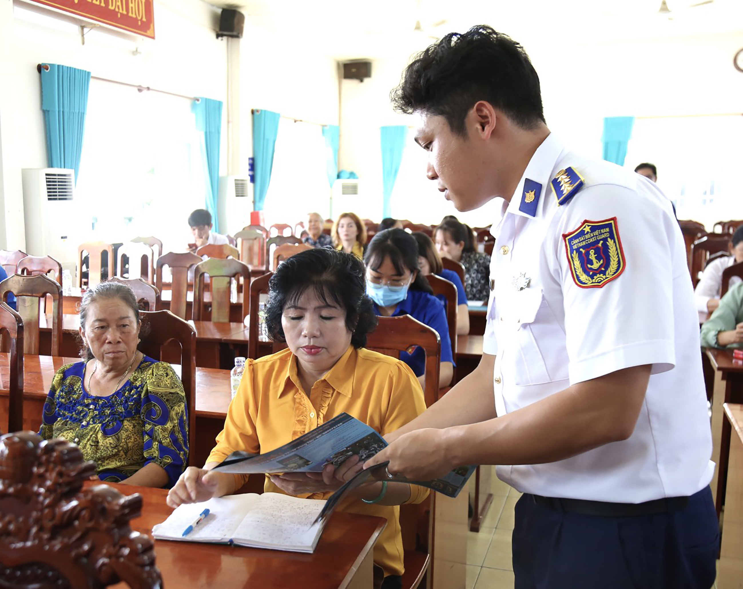 Cán bộ Vùng Cảnh sát biển 3 phát tờ rơi tuyên truyền về phòng, chống IUU cho cán bộ, đảng viên và nhân dân TT. Phước Hải, huyện Đất Đỏ.