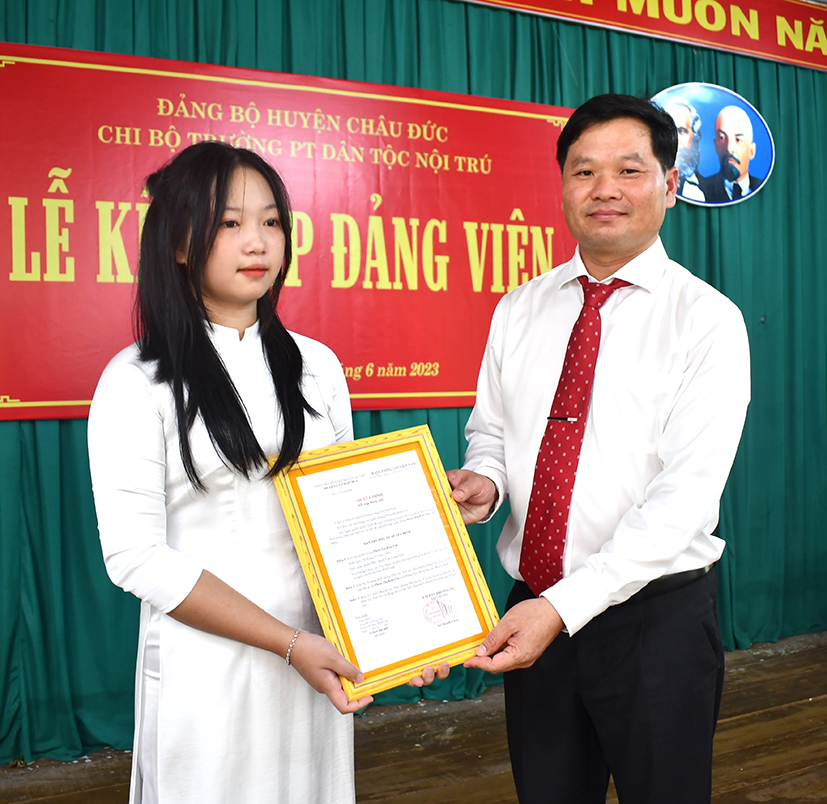 Ông Lê Thanh Liêm, Phó Bí thư Thường trực Huyện ủy Châu Đức trao quyết định và tặng hoa chúc mừng đảng viên Phan Thị Kim Chi (dân tộc Tày, SN 2005).