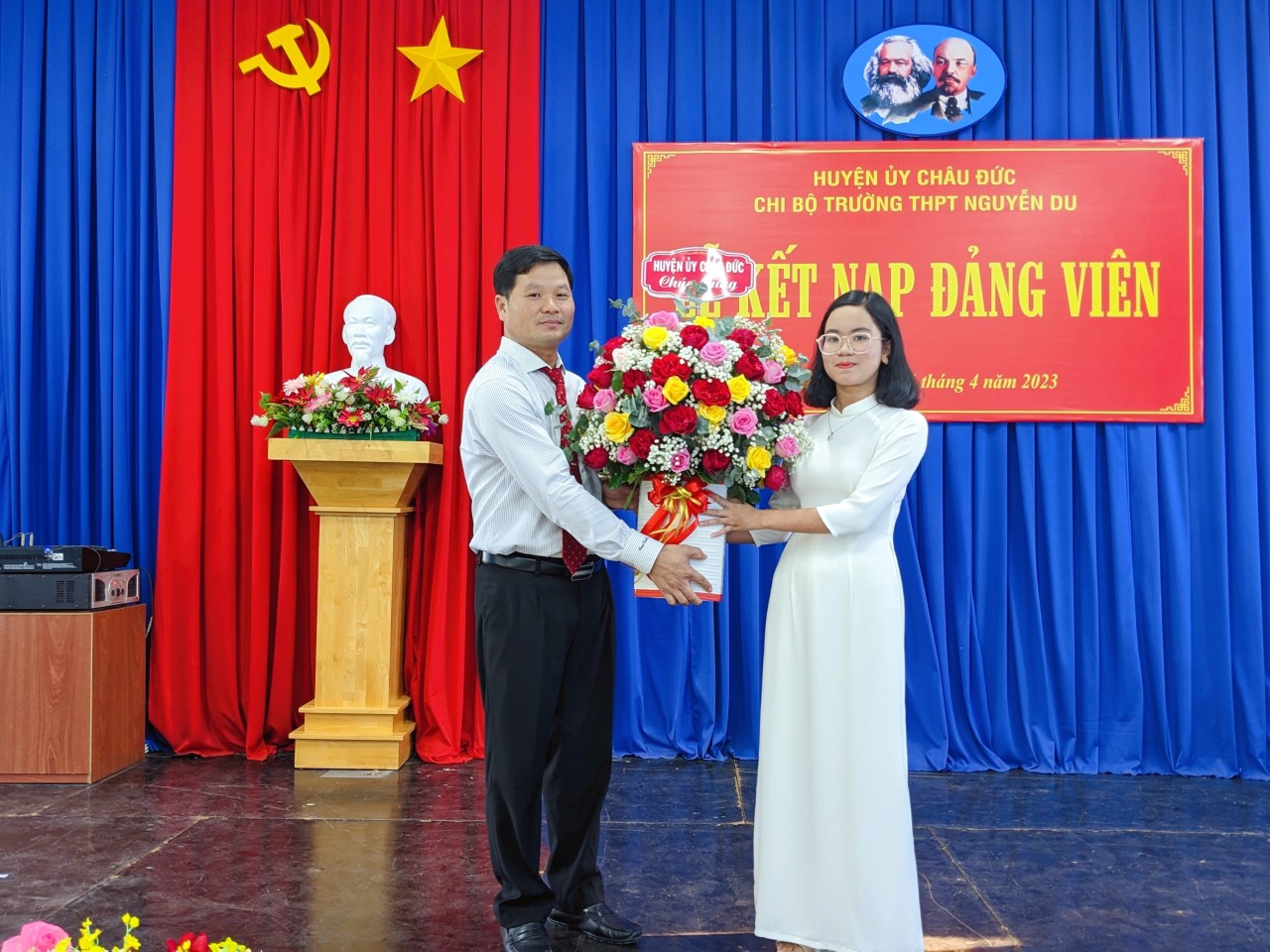 Ông Lê Văn Liêm, Phó Bí thư Thường trực Huyện ủy Châu Đức tặng hoa chúc mừng đảng viên mới  Đào Khánh Ngọc (HS Trường THPT Nguyễn Du, huyện Châu Đức) tại lễ kết nạp Đảng.