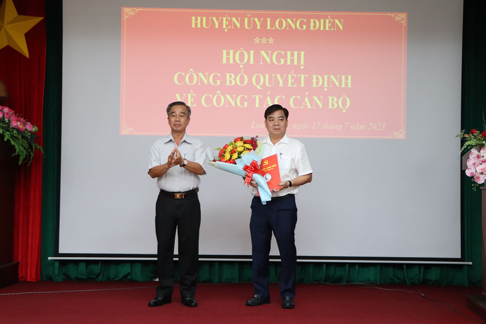 Phó Bí thư Thường trực Huyện ủy Võ Hữu Hạnh trao Quyết định, tặng hoa chúc mừng ông Nguyễn Minh Tâm.