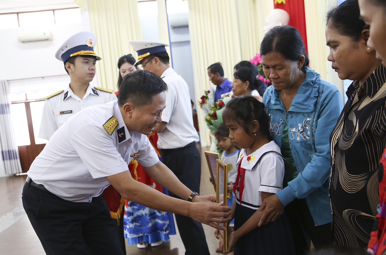 Lãnh đạo Vùng 2 Hải quân trao quyết định nhận đỡ đầu con ngư dân có hoàn cảnh khó khăn.