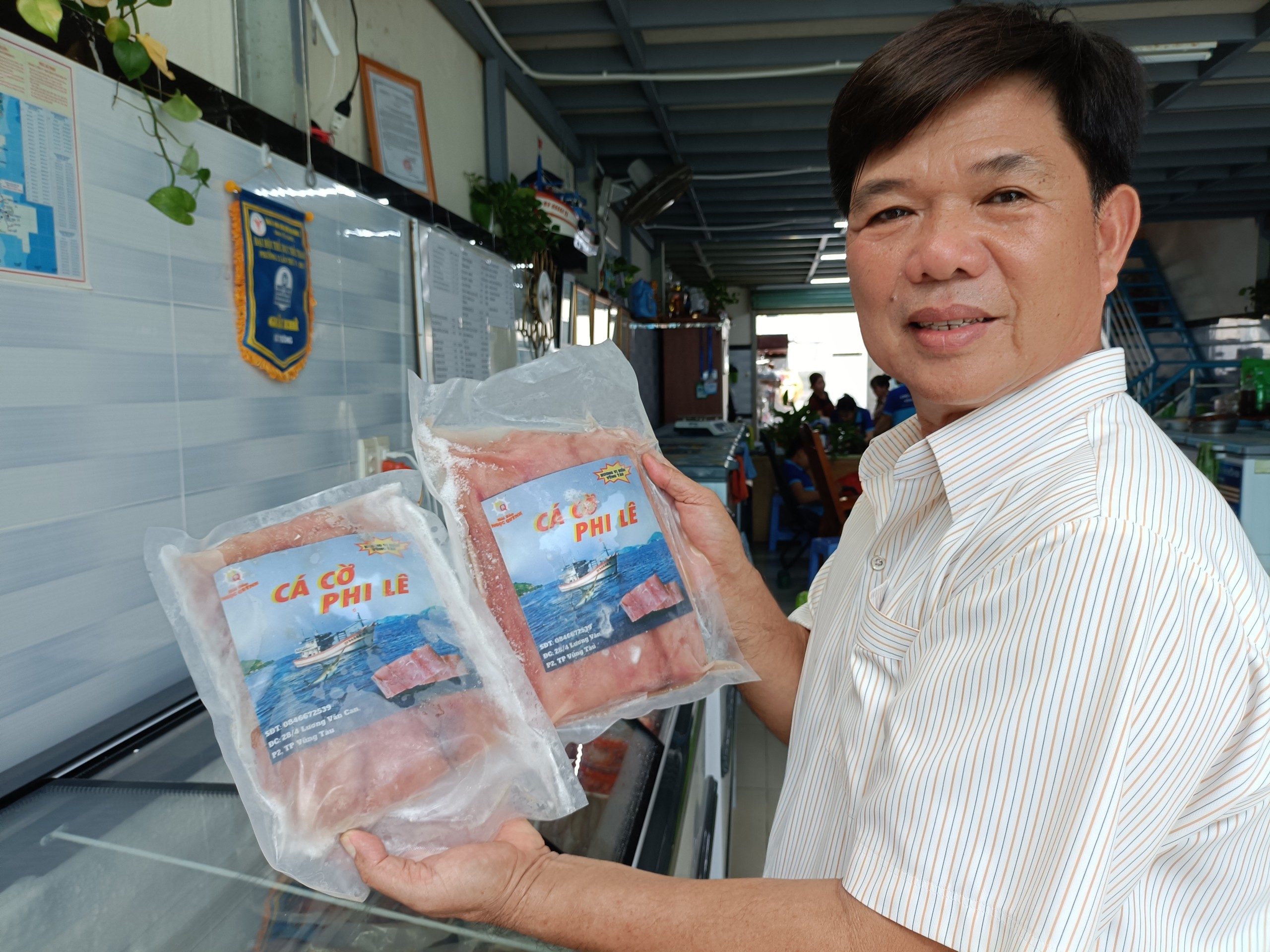 Ông Nguyễn Đình Ngọc với các sản phẩm cá sơ chế đông lạnh đánh bắt từ tàu cá của gia đình.