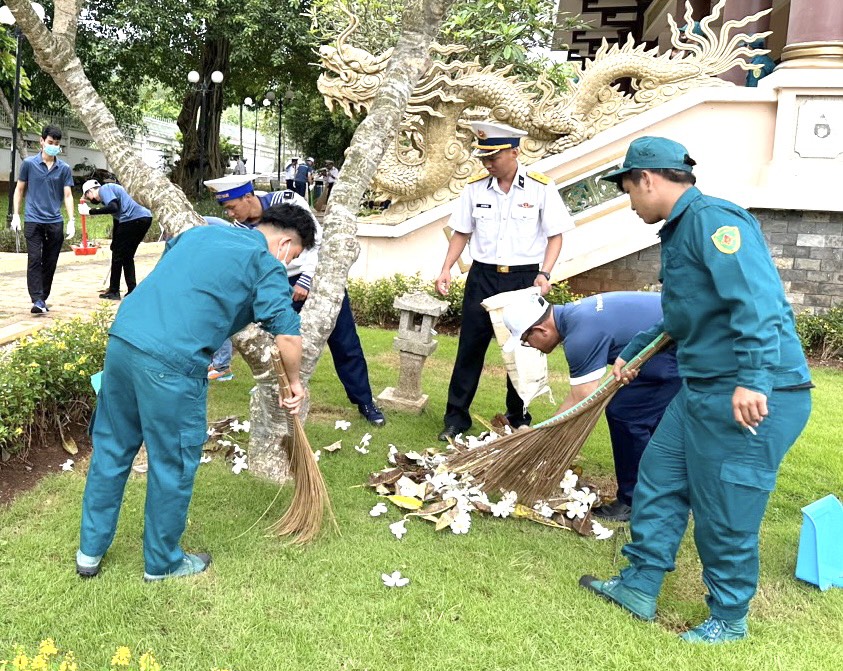 Cán bộ, chiến sĩ và đoàn viên thanh niên quét dọn lá cây, thu gom rác trong khuôn viên Nghĩa trang liệt sĩ xã Long Sơn.