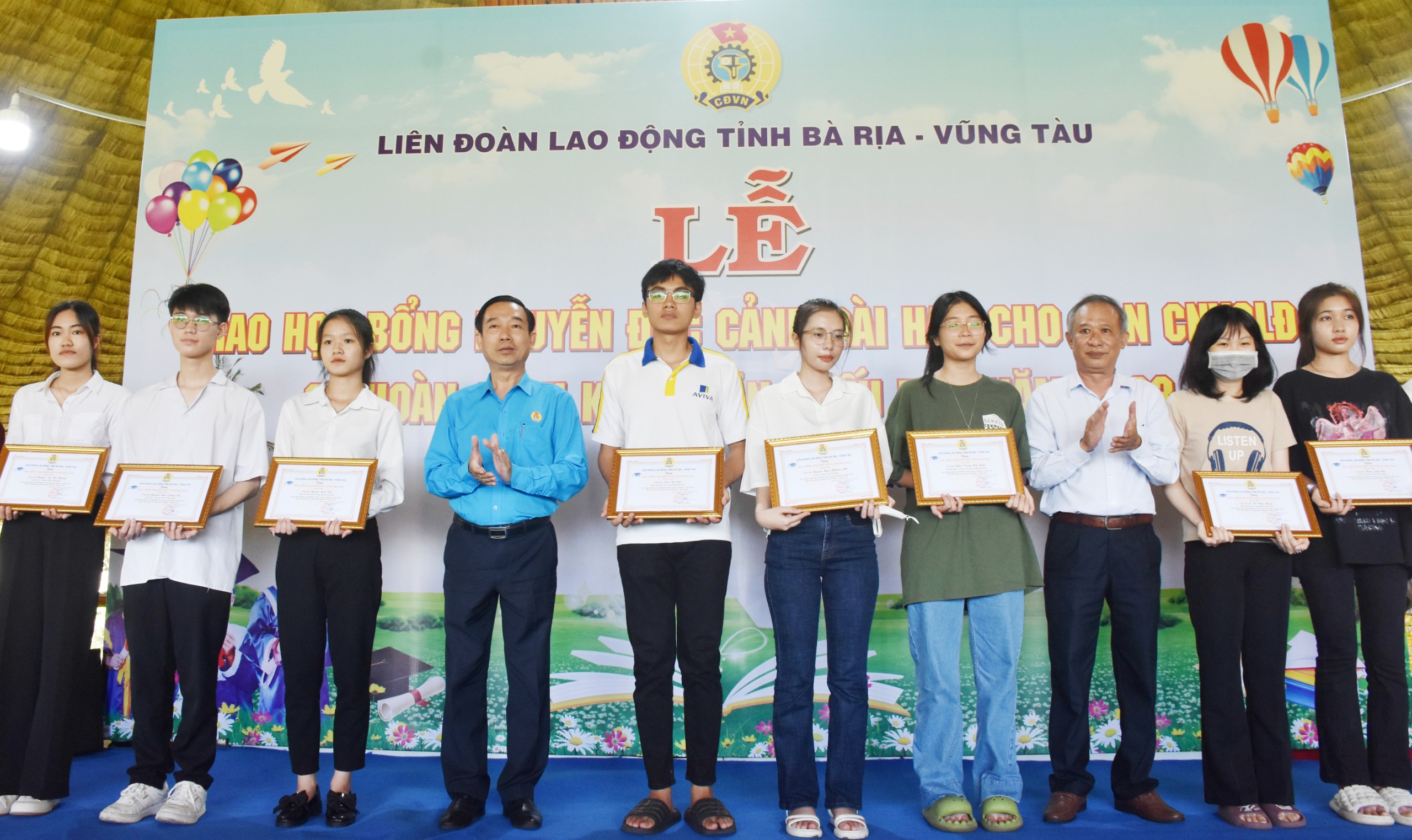 Ông Lê Văn Hòa, Chủ tịch LĐLĐ tỉnh và ông Lương Đức Đích, Chủ tịch Hội Khuyến học tỉnh trao học bổng cho các em HS-SV