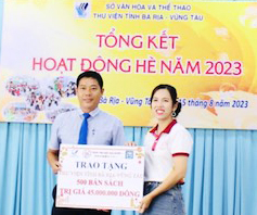 Bà Trần Phạm Kim Hoàn, Giám đốc Trung tâm Nhật ngữ Hiyori trao biển tượng trưng tặng sách đến ông Trần Công Sơn, Giám đốc Thư viện tỉnh.