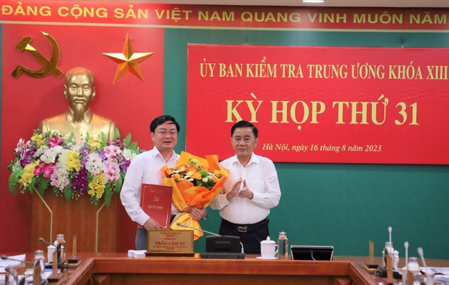 Ông Trần Cẩm Tú, Ủy viên Bộ Chính trị, Bí thư Trung ương Đảng, Chủ nhiệm Ủy ban Kiểm tra Trung ương trao quyết định và tặng hoa chúc mừng ông Nguyễn Văn Quyết