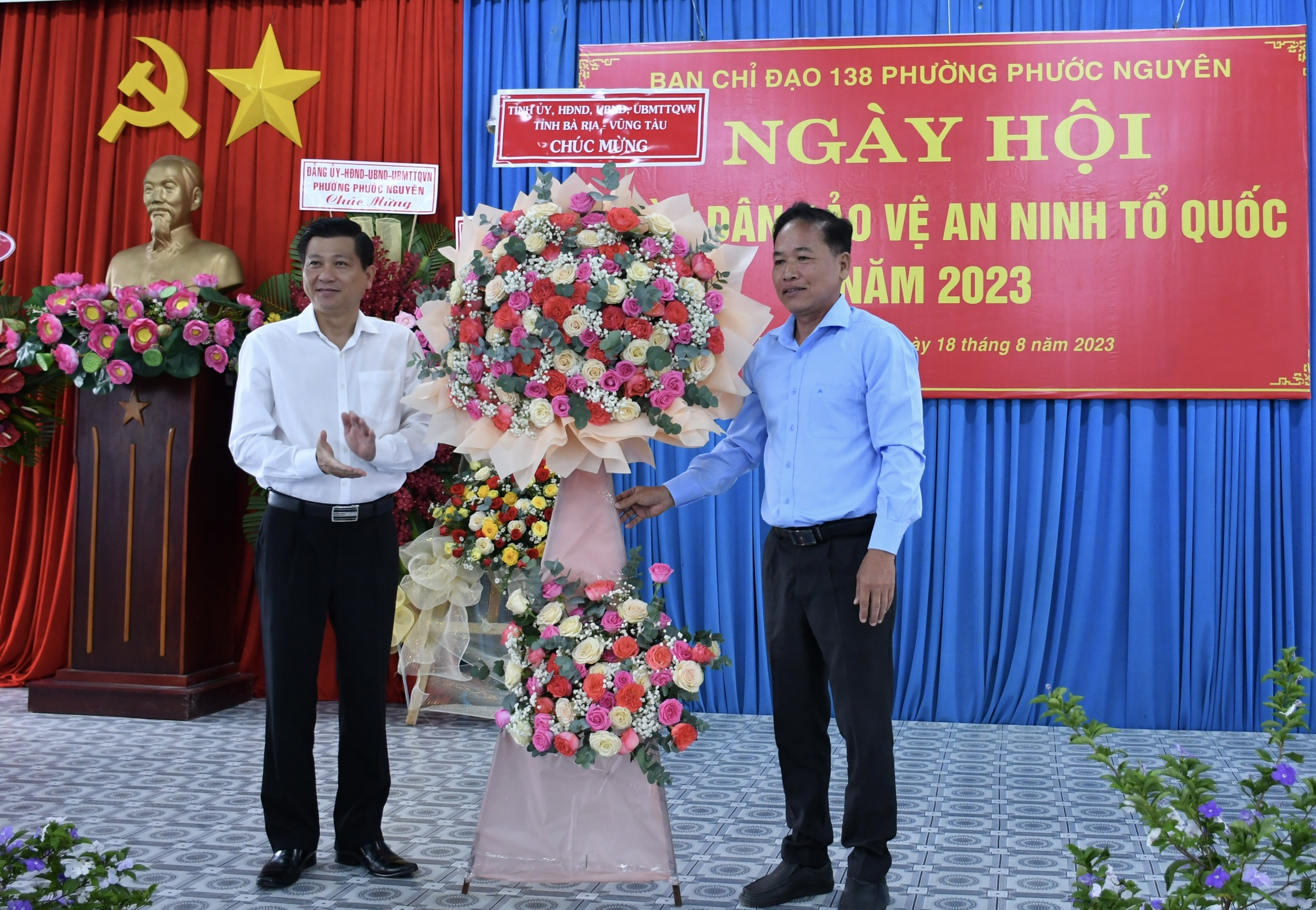 Ông Trần Văn Tuấn, Bí thư Thành ủy Bà Rịa (bên trái) trao hoa chúc mừng Ngày hội 