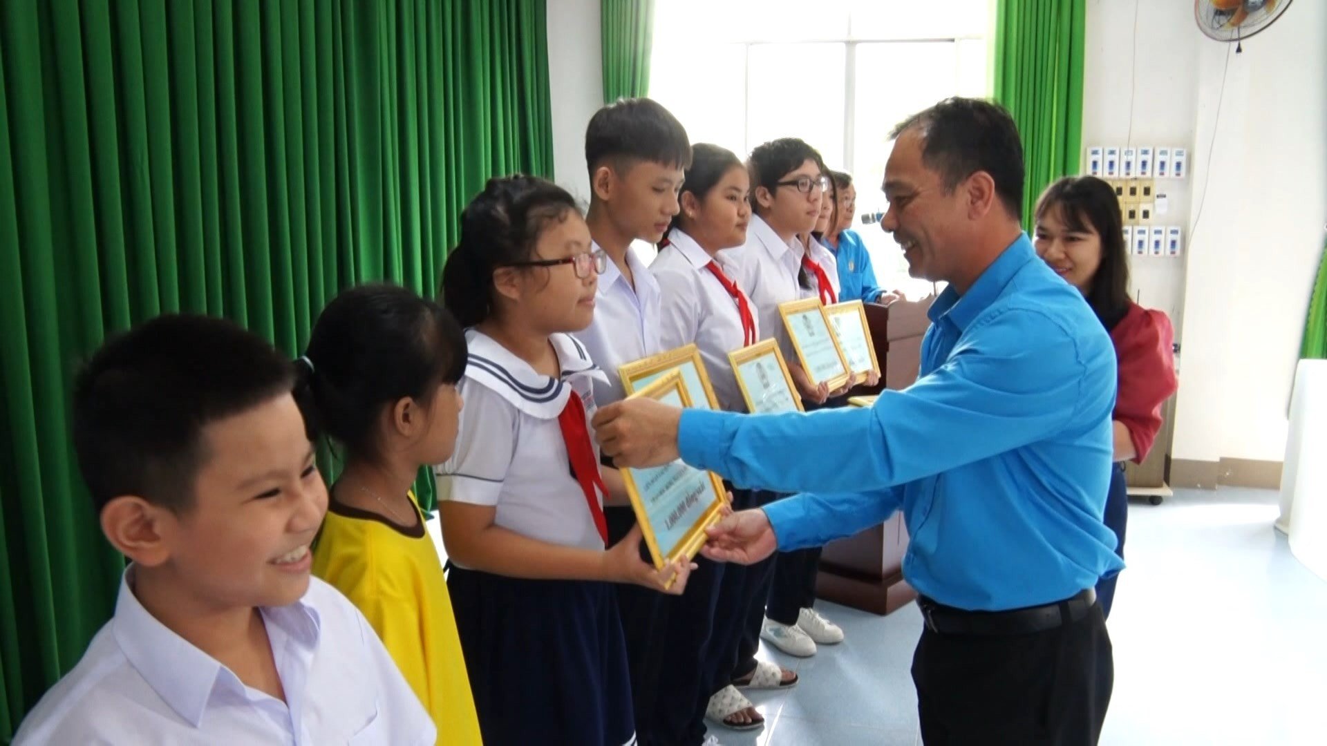 Ông Kiều Minh Sơn, chủ tịch LĐLĐ huyện Long Điền trao học bổng cho học sinh trên địa bàn huyện.