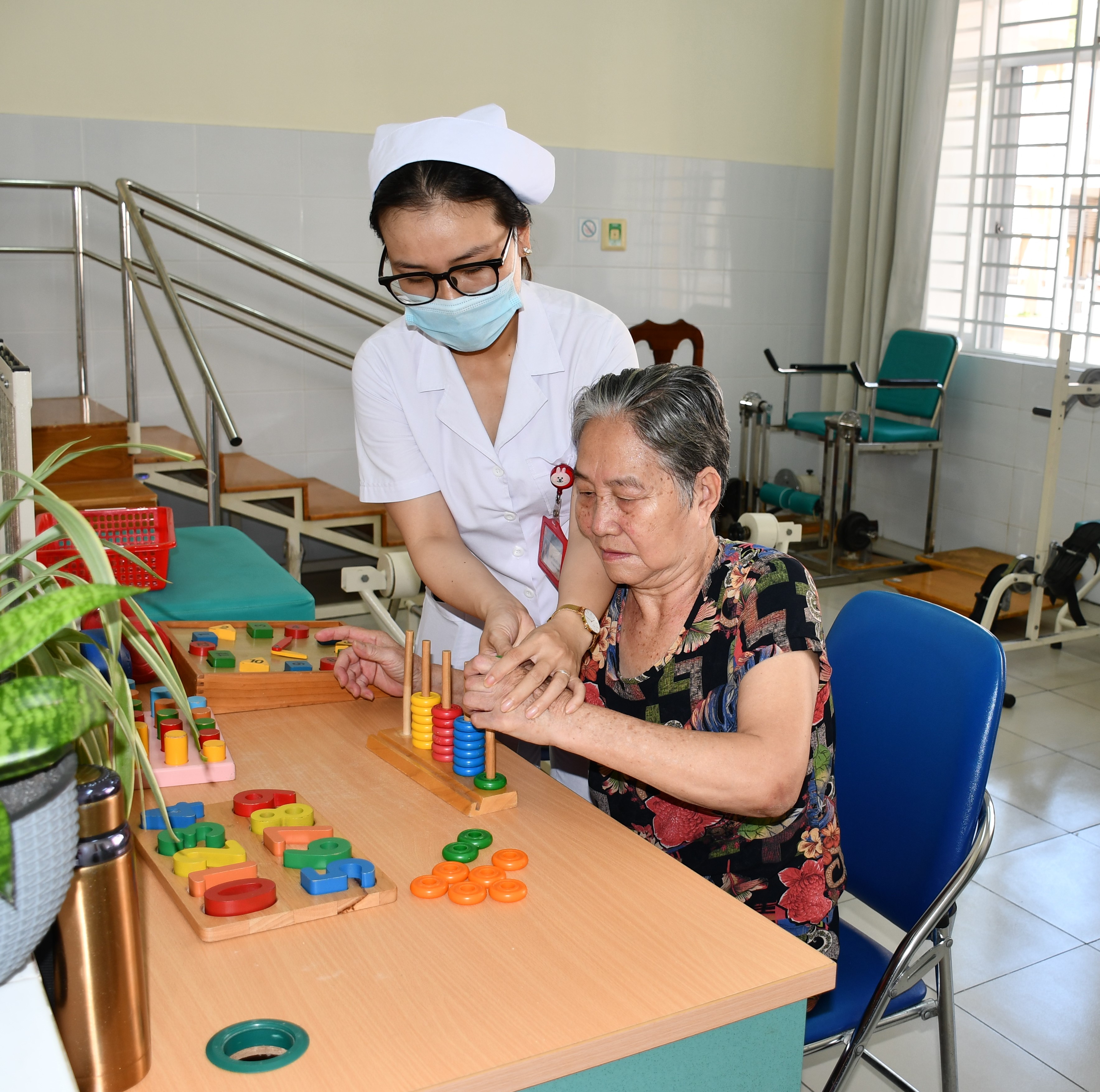 Bà Võ Kim Đảnh được nhân viên y tế Bệnh viện Y học cổ truyền tỉnh hỗ trợ tập cầm nắm.