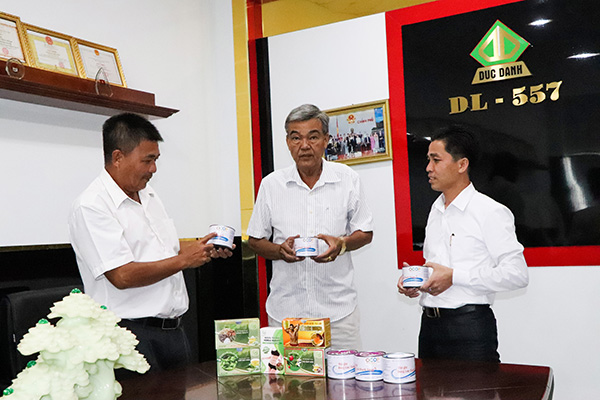 Anh Cao Văn Tuyến (bên phải), giới thiệu sản phẩm thịt ghẹ đóng lon với lãnh đạo Hội Nông dân xã Phước Hưng.