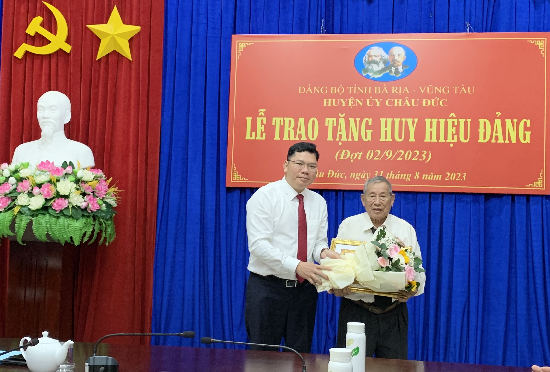 Ông Hoàng Nguyên Dinh, Bí thư Huyện ủy Châu Đức trao Huy hiệu 70 năm tuổi Đảng cho đang viên Trương Quang Ngọ (92 tuổi, Đảng bộ xã Suối Nghệ). 