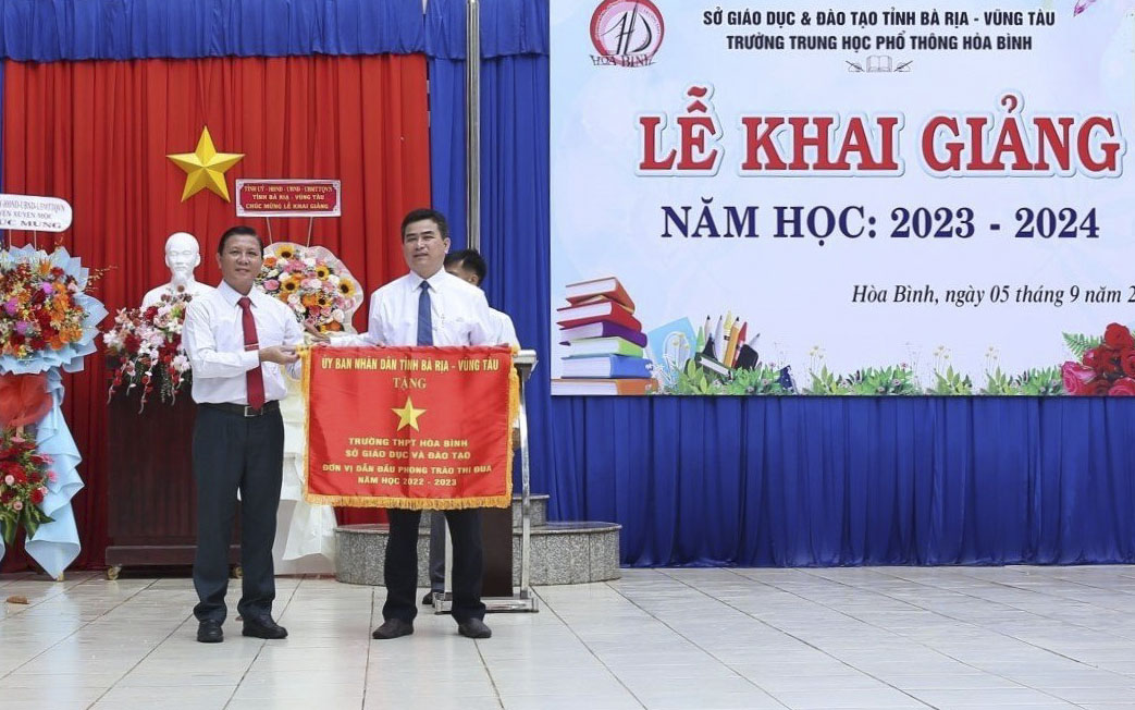 ông Mai Minh Quang, Chủ tịch Hội Nông dân tỉnh trao Cờ thi đua của UBND tỉnh cho tập thể Trường THPT Hoà Bình (huyện Xuyên Mộc).