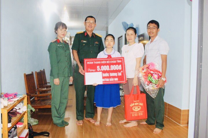 Lãnh đạo Phòng Chính trị và Đoàn Thanh niên Bộ CHQS tỉnh trao quyết định nhận đỡ đầu em Lê Huỳnh Bảo Nhi.