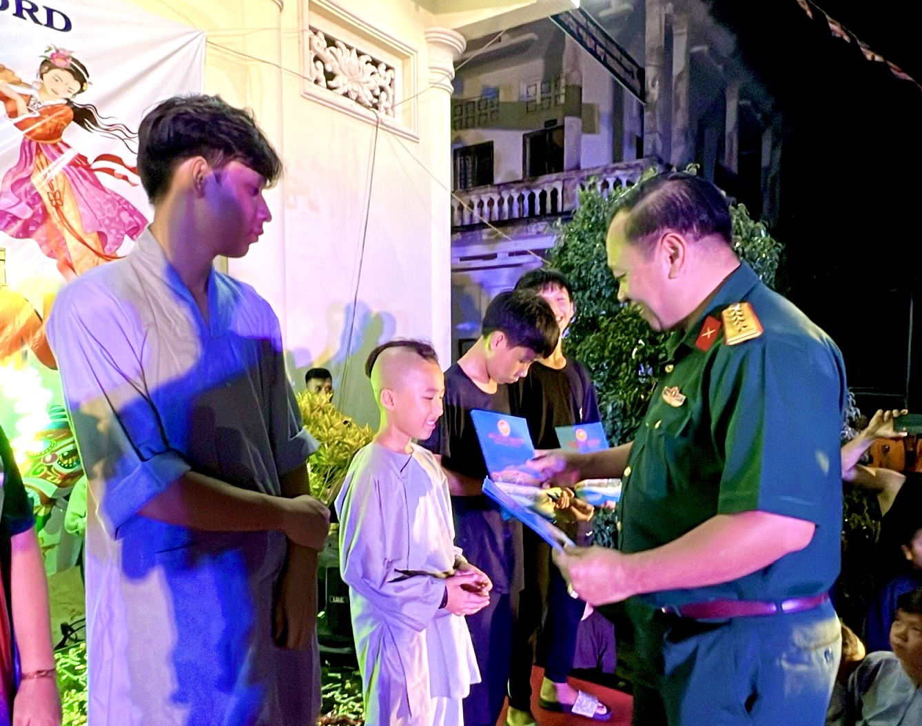 Đại tá Nguyễn Thành Trung, Chính ủy Bộ CHQS tỉnh trao học bổng cho các em thiếu nhi mồ côi đang được nuôi dưỡng tại chùa Hộ Pháp. 