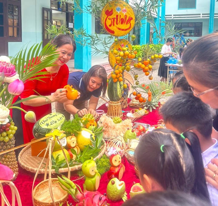 Các em học sinh cùng cô giáo trang trí mâm cỗ Trung thu.