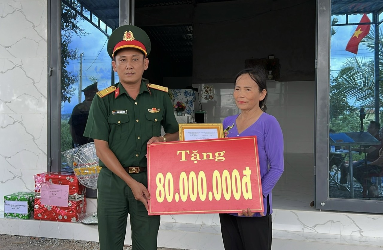 Đại diện Ban CHQS huyện Long Điền trao biểu trưng tài trợ “Nhà tình nghĩa quân – dân” cho gia đình bà Trần Thị Sương.